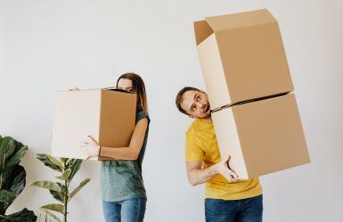 man en vrouw dragen verhuisdozen
