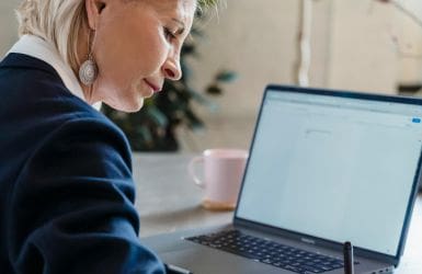 Elderly woman behind laptop