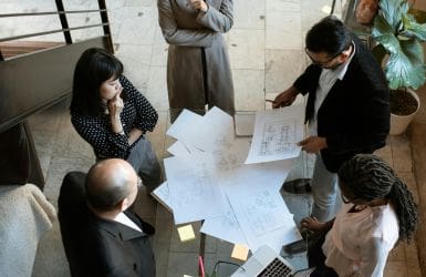 ludzie przy stole z projektami