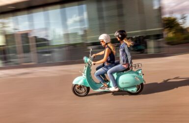 Two women on a blue scooter